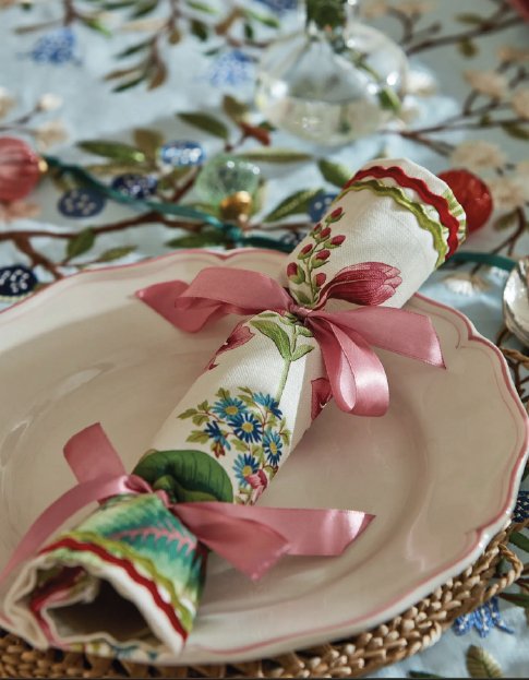 Handmade fabric crackers wrapped in colourful Sanderson floral fabric displayed on a decorative table setting with ribbon