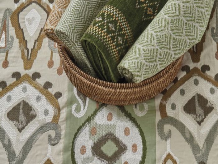 Assortment of green patterned textiles displayed on Turfan fabric by Nina Campbell featuring an ikat-inspired design